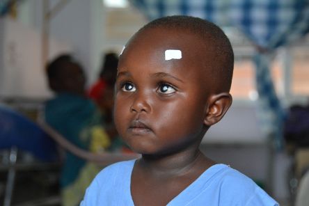 Kind mit zwei kleinen Pflastern auf der Stirn über den Augen